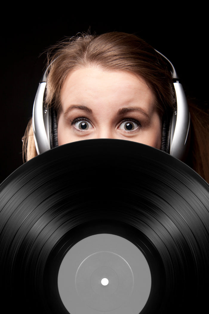 Girl with headphones holding vinyl record